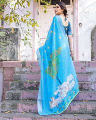 Woman wearing a blue saree with floral patterns on steps outdoors