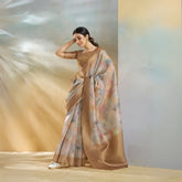 Woman wearing a beige saree with a floral pattern against a gradient background