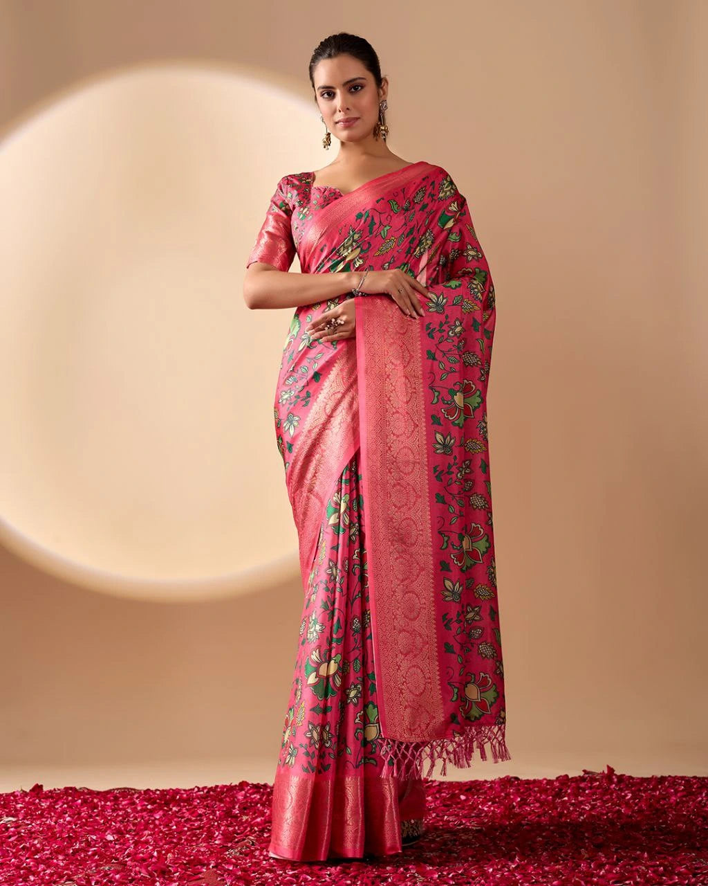 Woman wearing a pink saree with floral patterns on a beige background