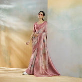 Woman in a pink saree standing against a neutral background