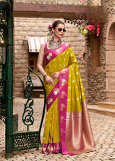 Woman in a yellow and pink saree with floral decorations in an outdoor setting