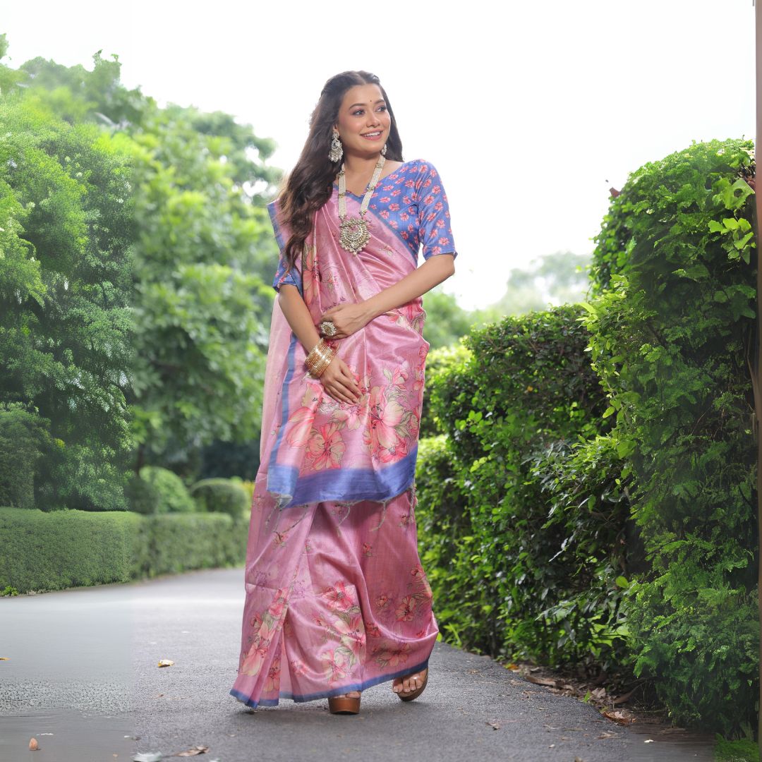 Woman wearing light pink floral print saree standing outdoors in elegant traditional Indian ethnic outfit