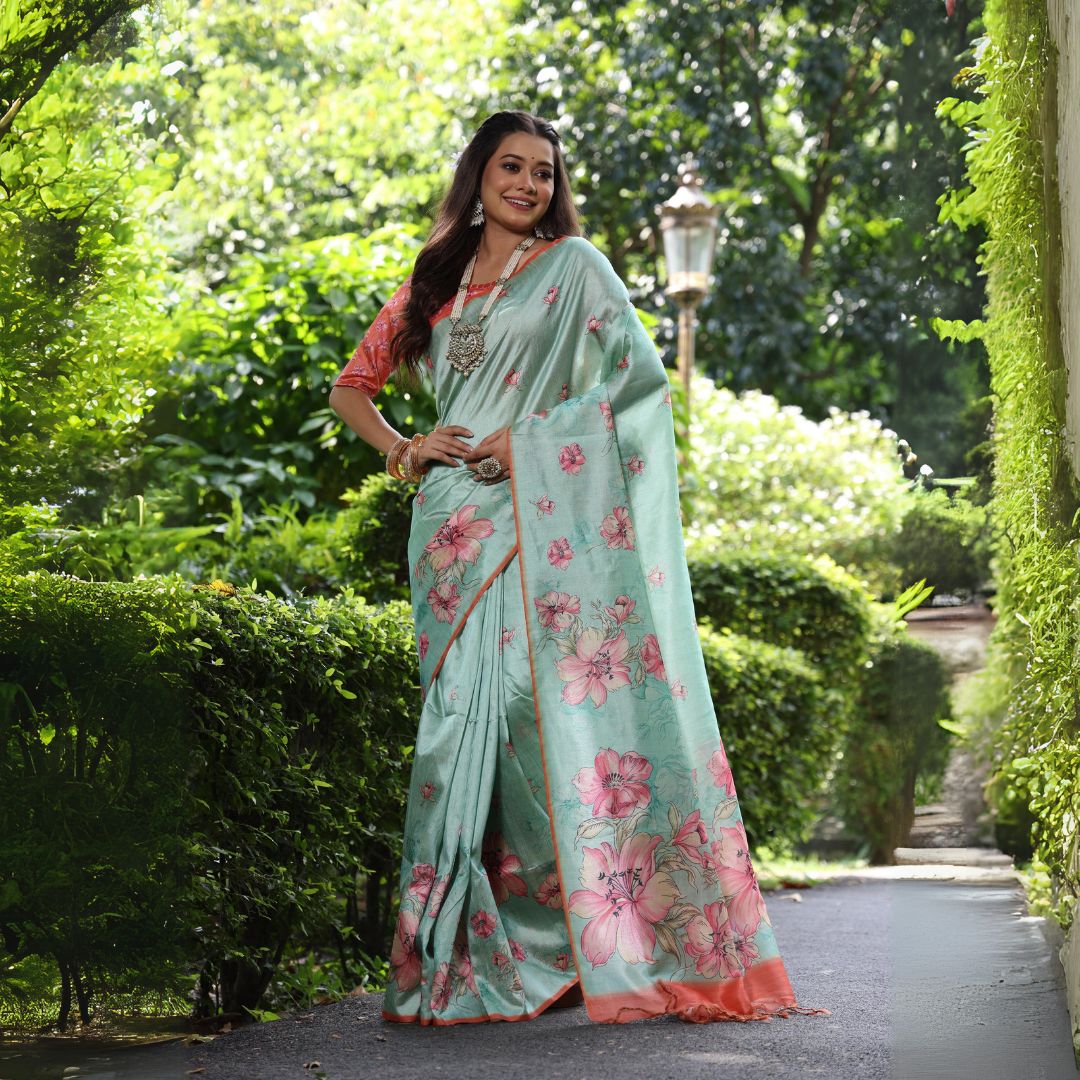Woman wearing pastel sea green floral print saree posing outdoors in elegant traditional Indian