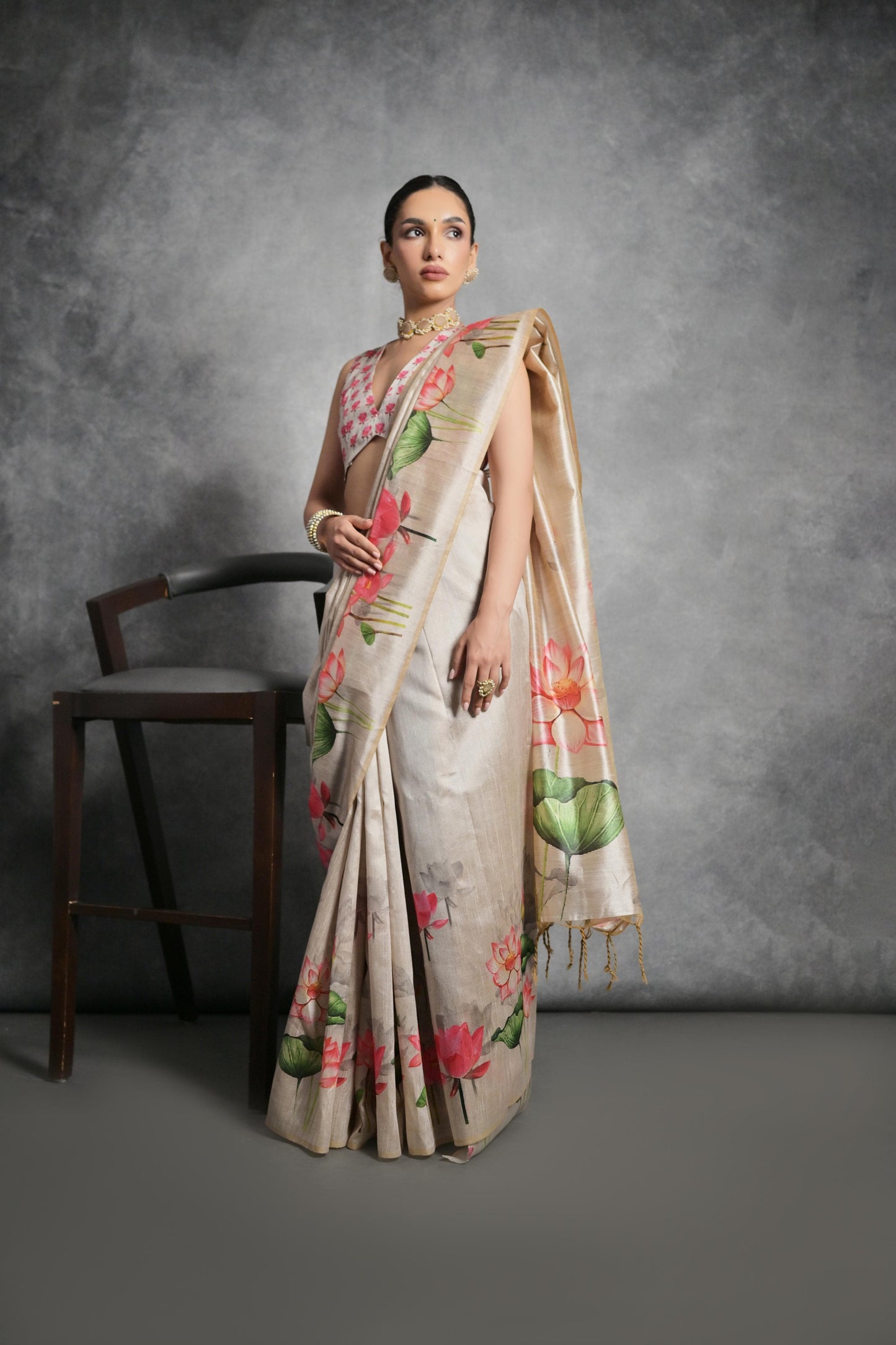 Woman wearing light beige floral printed saree posing outdoors in traditional Indian ethnic attire