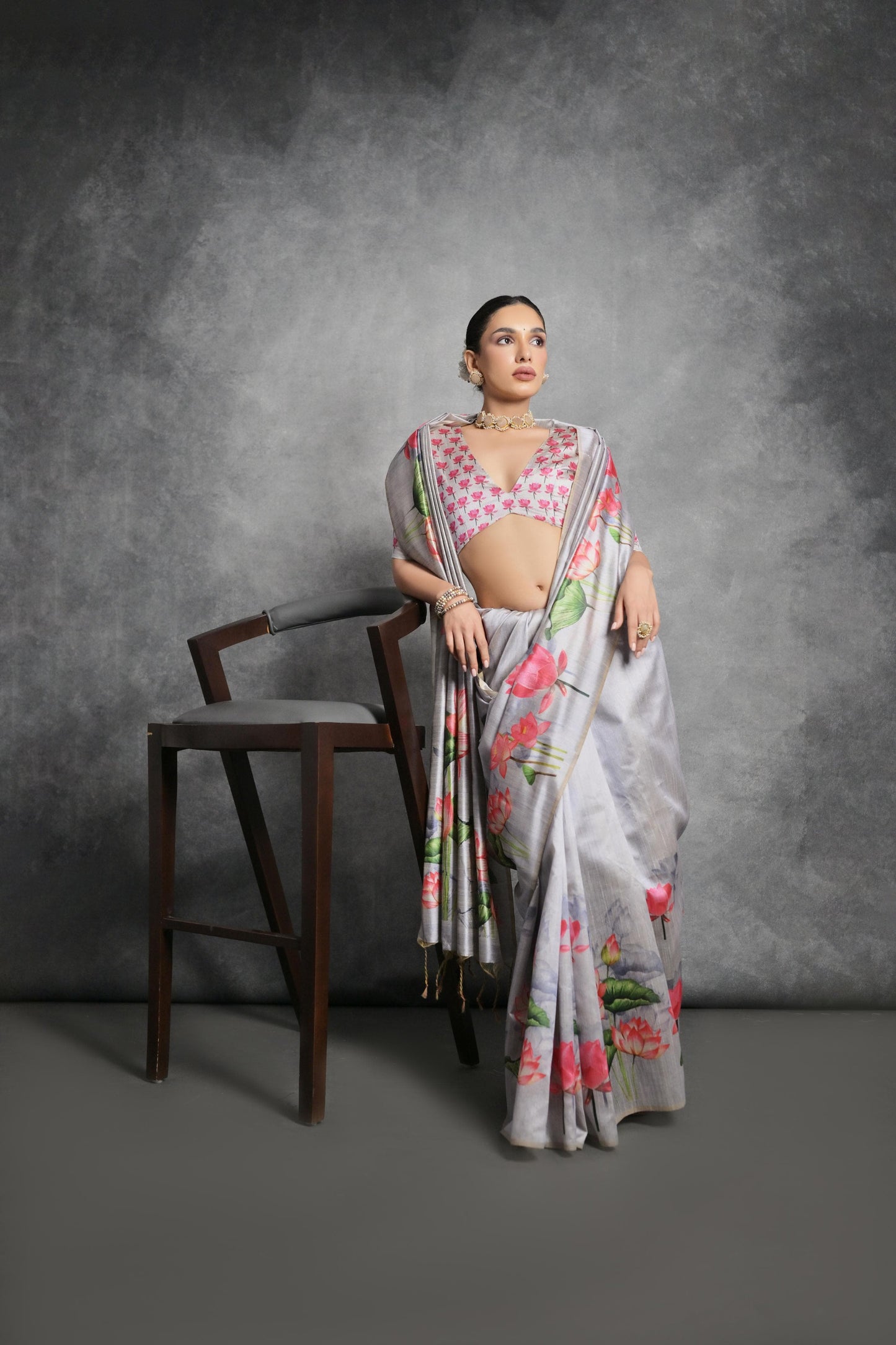 Woman wearing light gray floral printed saree posing outdoors in traditional Indian ethnic attire