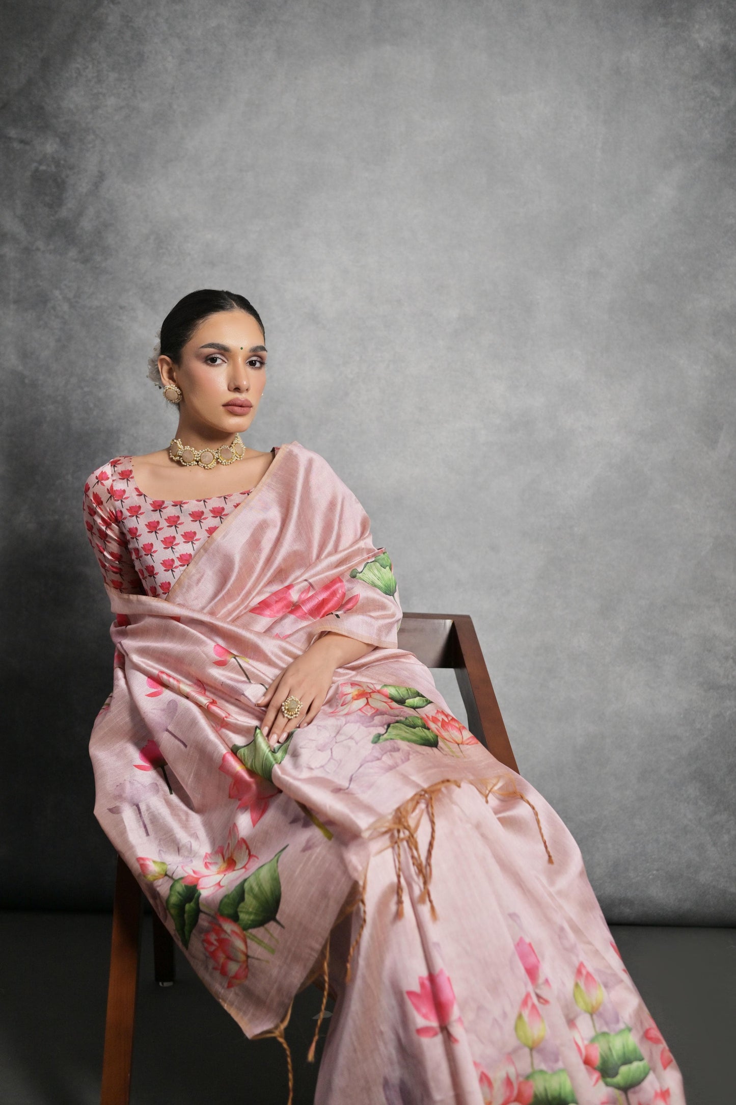 Woman wearing soft pink floral printed saree standing outdoors in elegant traditional Indian ethnic attire