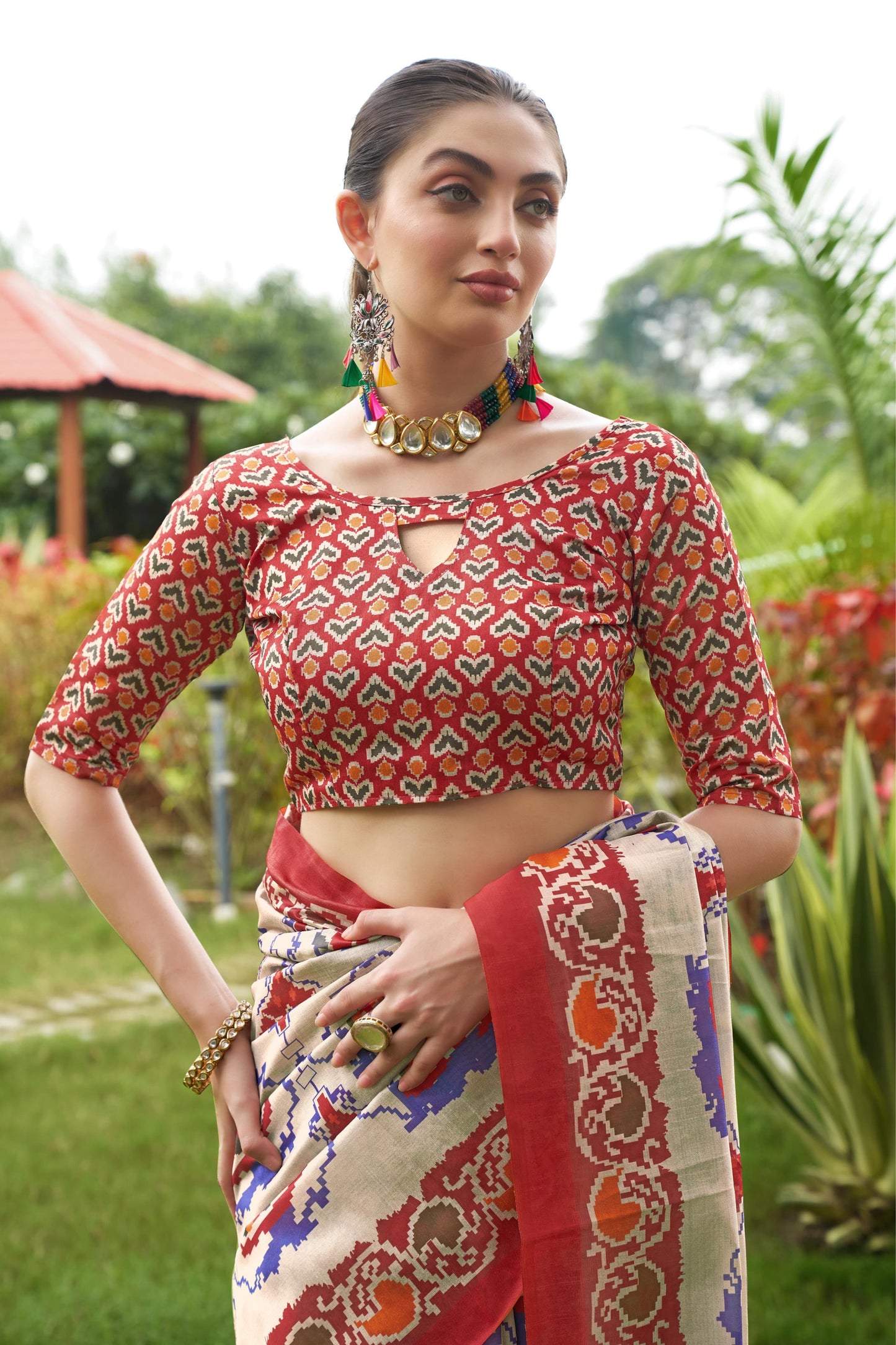 Close up of light beige saree with Patola print and red border