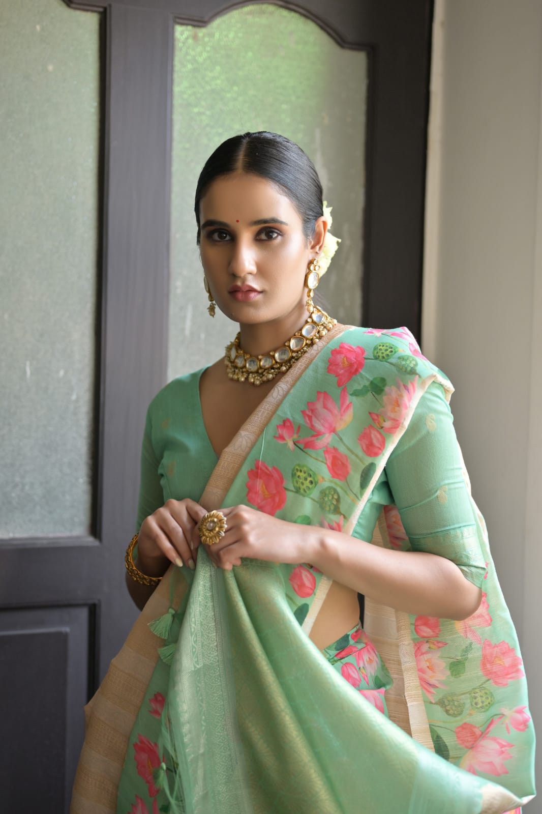 Graceful light pastel green saree adorned with intricate zari work design