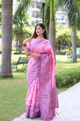 Woman in light pink traditional weaving saree showcasing elegant ethnic style in garden background