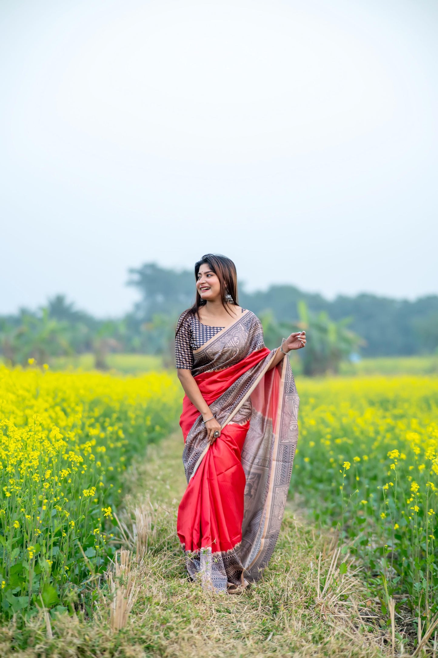 Woman wearing red Madhubani print saree posing outdoors in traditional Indian ethnic wear