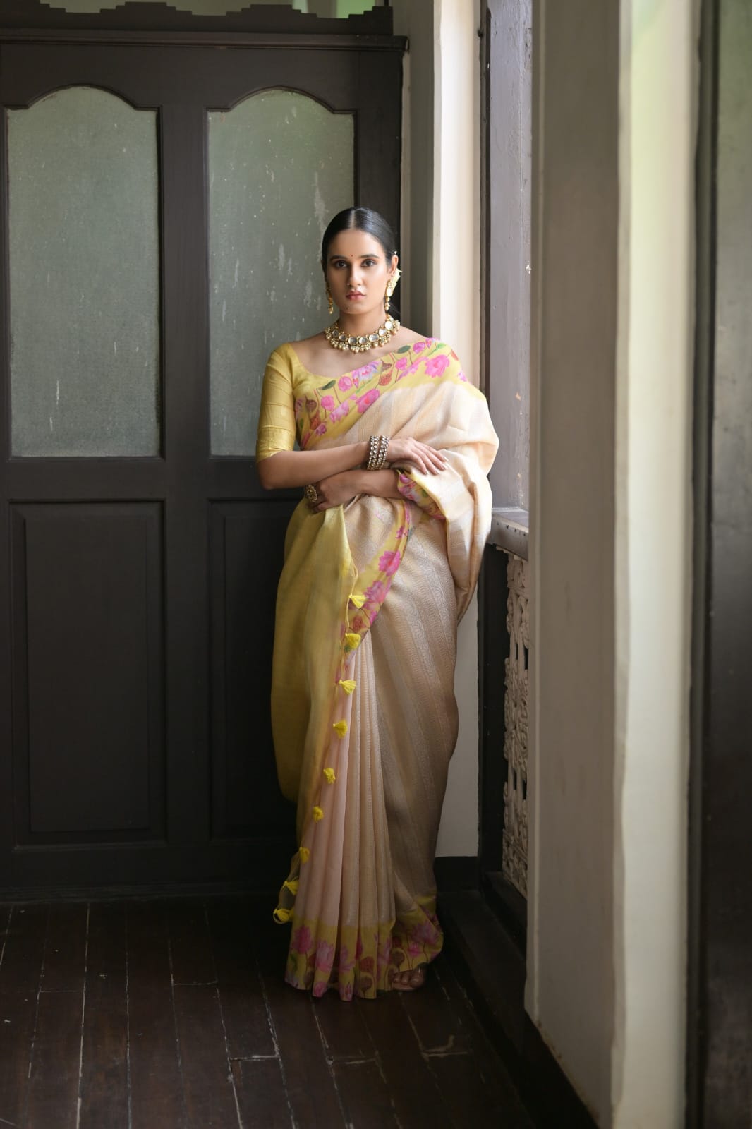 Pale yellow saree featuring rich zari work and vibrant floral border desige
