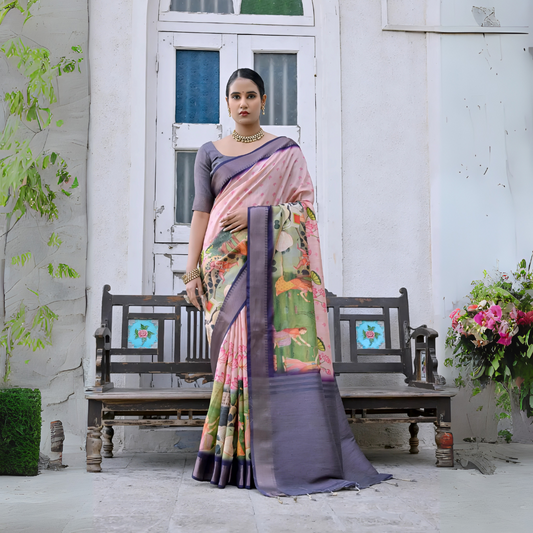 Woman wearing a pastel multicolor floral printed saree with a contrasting purple border and a grey blouse, accessorized with traditional gold jewelry, elegantly standing in front of classic white arched doors and windows beside a vintage wooden bench, with greenery and a floral arrangement in a heritage courtyard setting.
