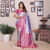 Woman in a pink and silver saree standing in a room with decorative elements.