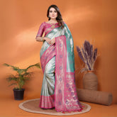 Woman in a pink and gray saree standing against an orange background with decorative elements.