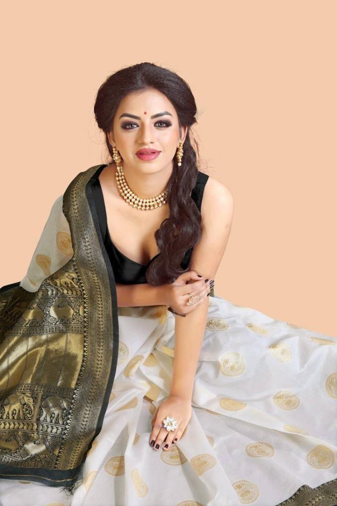 White banarasi jacquard saree with gold circular motifs featuring luxurious elephant design pallu black sweetheart neckline blouse pearl jewelry traditional Indian wedding wear statement ring