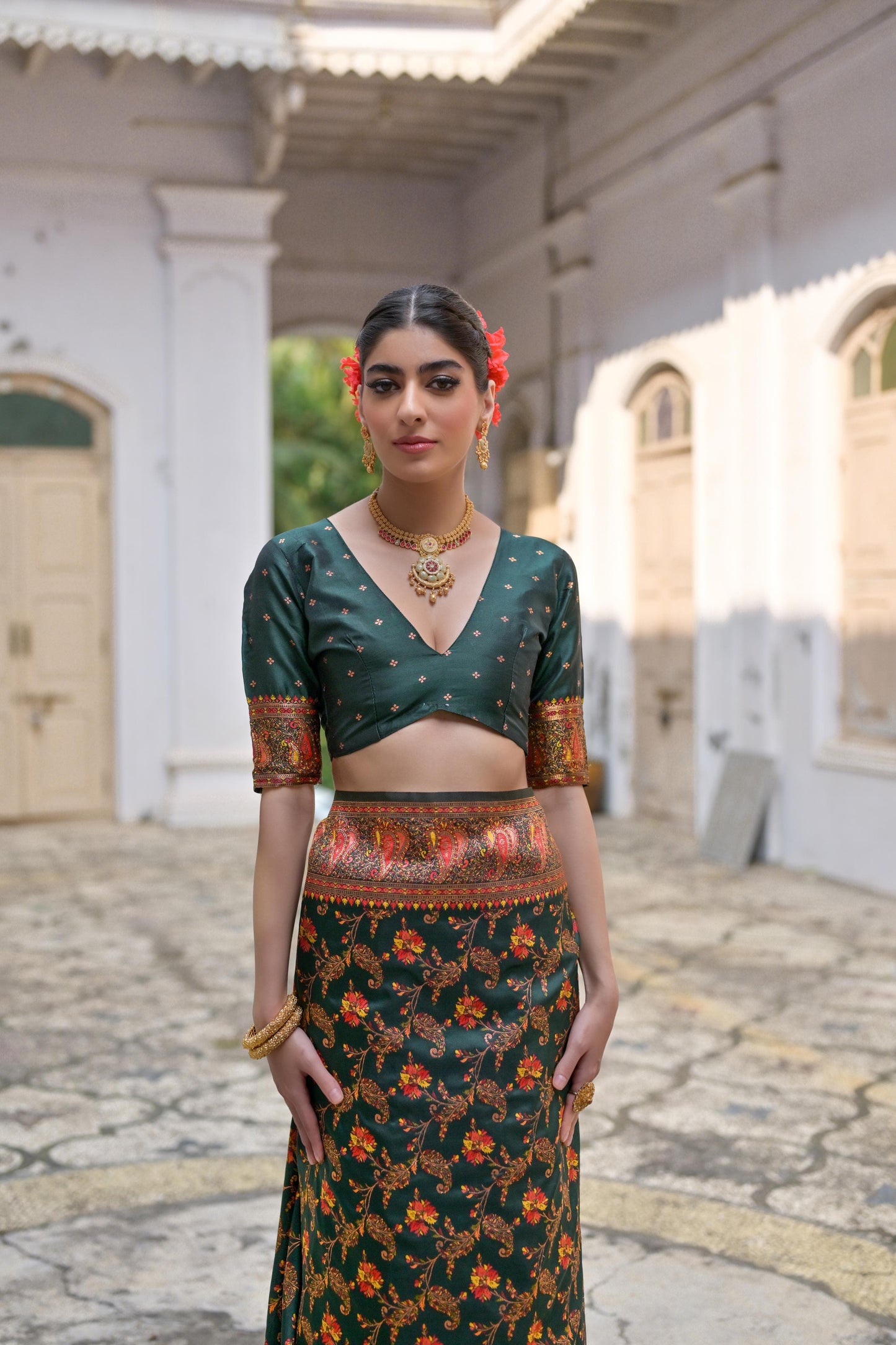 Woman wearing deep green Zari work saree posing outdoors in traditional Indian ethnic attire