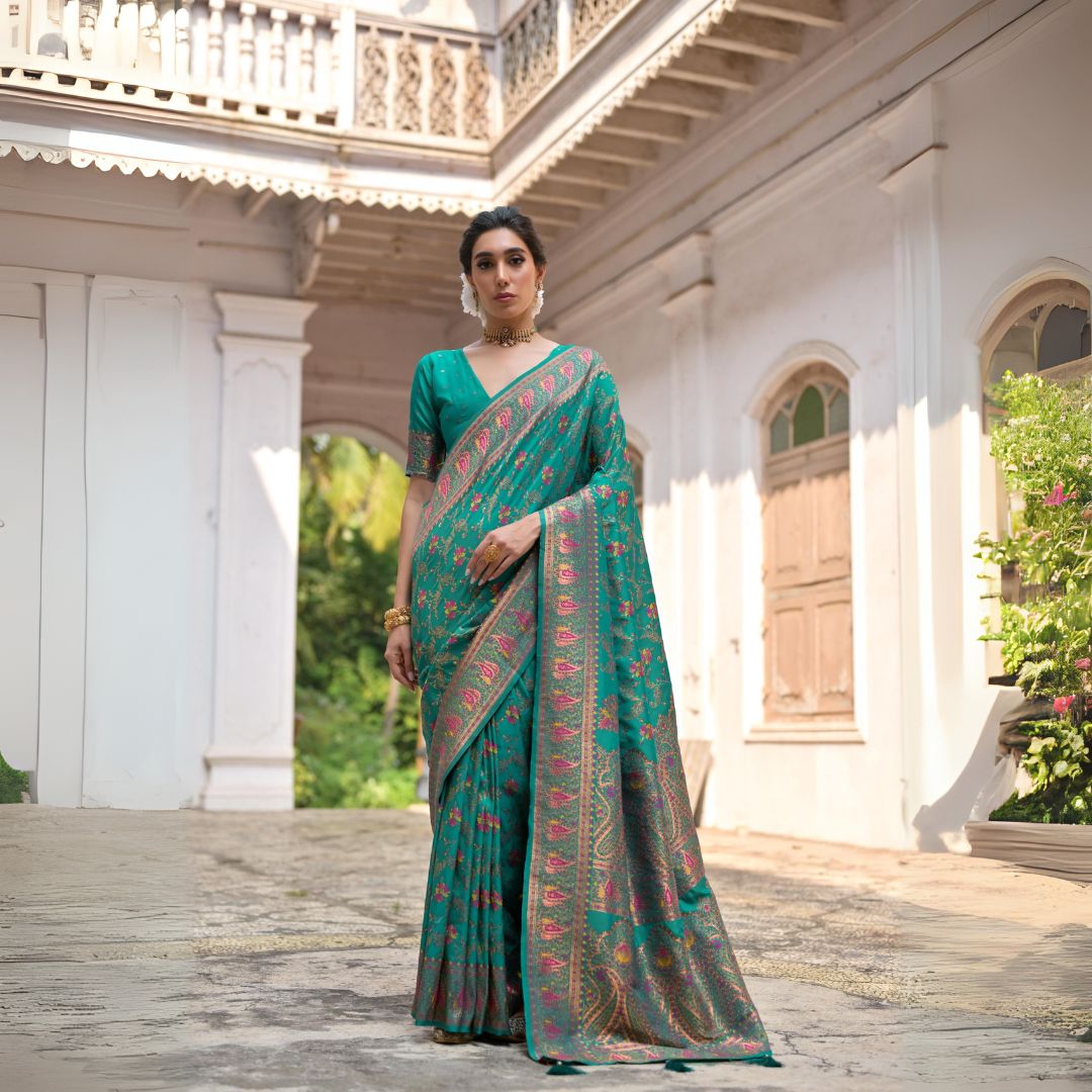 Woman wearing deep teal Zari work saree posing outdoors in elegant traditional Indian ethnic attire