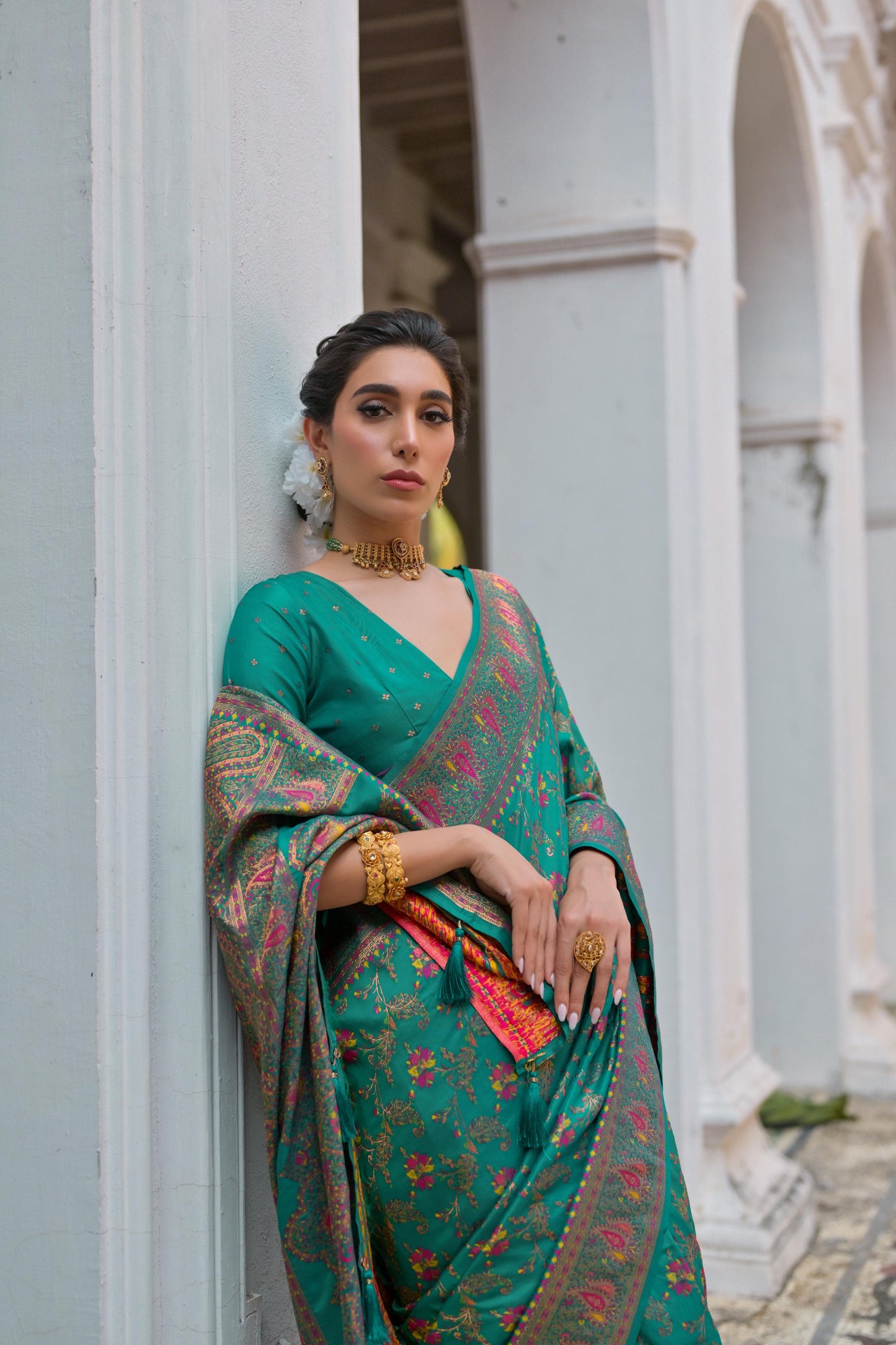Woman wearing deep teal Zari work saree posing outdoors in elegant traditional Indian ethnic attire