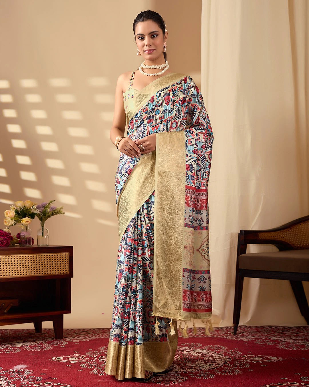 Woman wearing a traditional saree with a colorful pattern in a well-lit room.