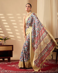 Woman in a traditional saree with a patterned shawl in a room with a red carpet.