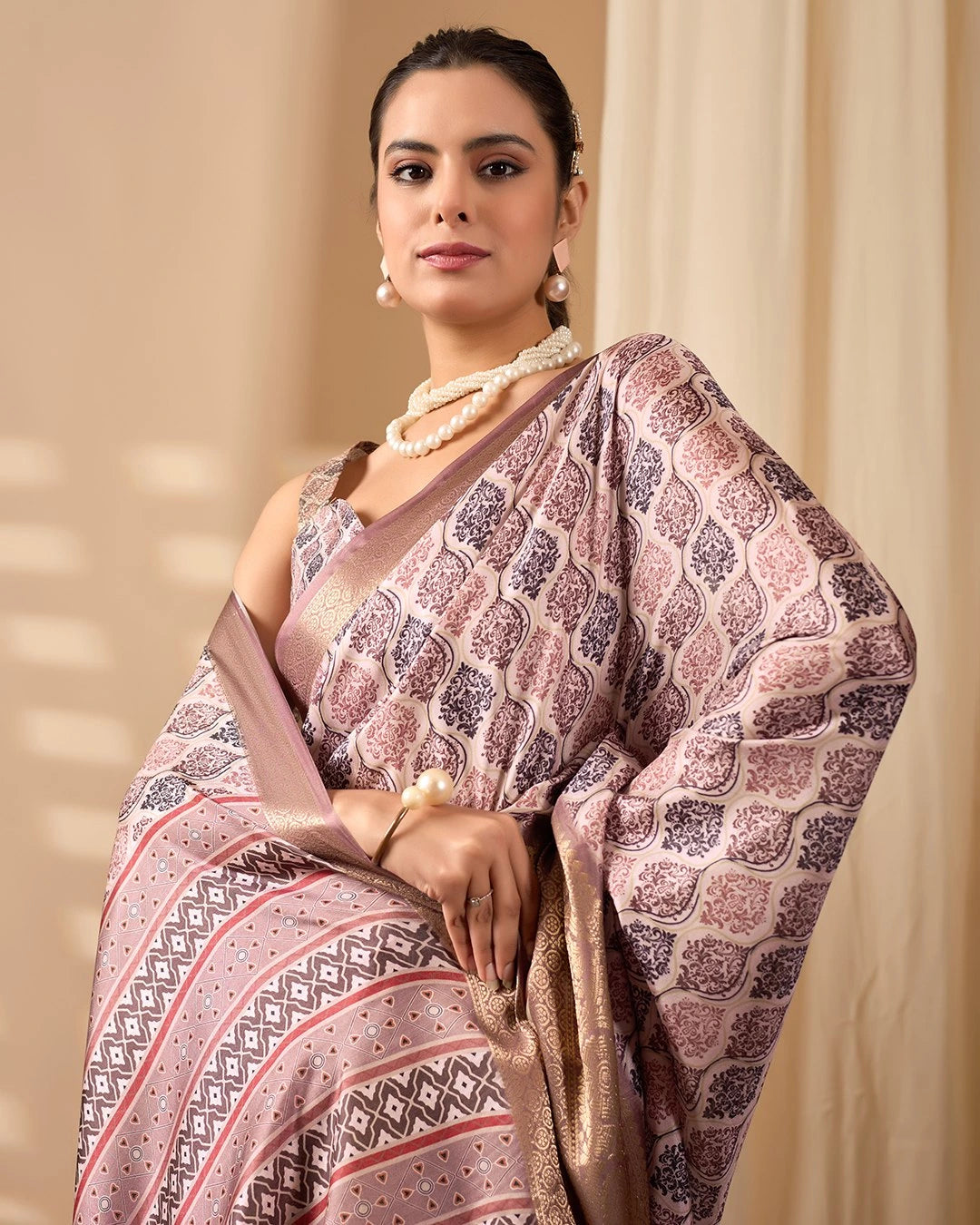 Woman wearing a patterned saree with a beige background