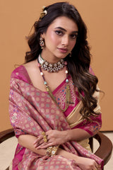Woman in traditional pink and gold saree with jewelry against a beige background
