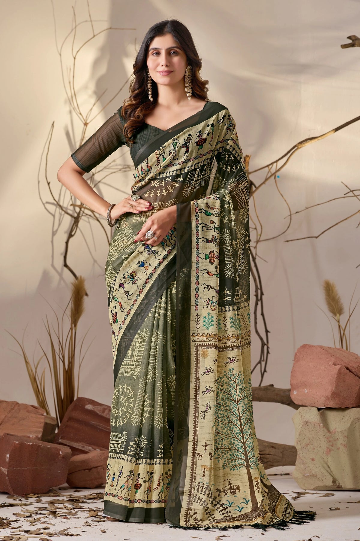 Woman wearing a traditional saree with intricate patterns against a natural background