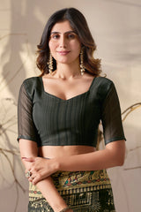 Woman wearing a black blouse with a patterned skirt against a neutral background