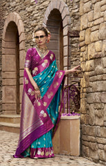 Woman in a traditional saree standing in front of stone arches.