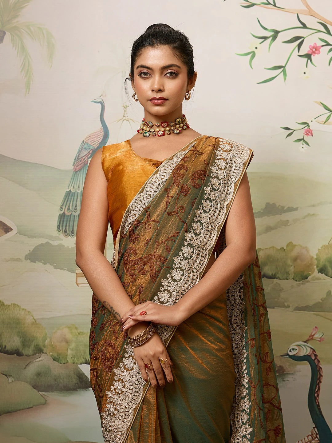 Woman in a traditional saree with a decorative background featuring peacocks.