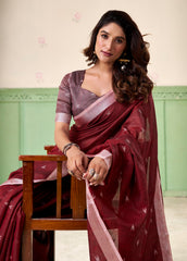 Woman in a maroon saree with a green background