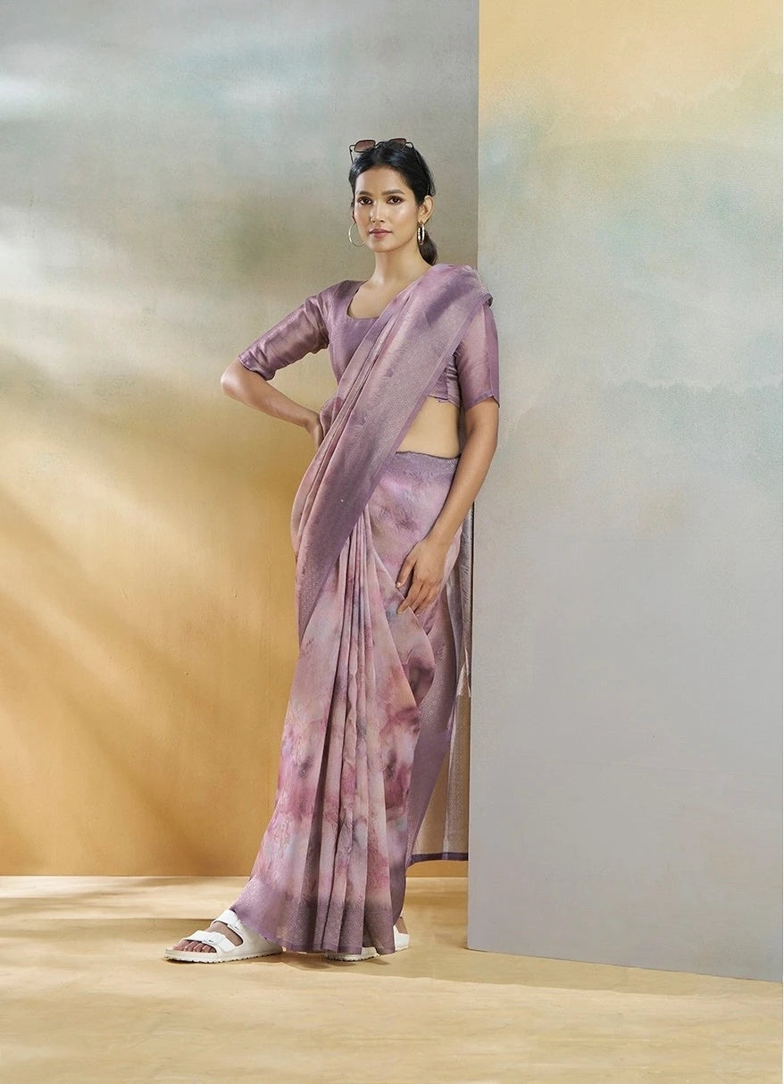 Woman wearing a purple saree with a plain background