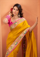 Woman wearing a yellow saree with pink blouse against a brown background