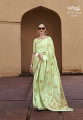 Woman wearing a light green saree with a traditional setting, featuring the Raphae brand.