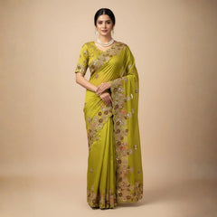 Woman wearing a green saree with floral patterns on a beige background
