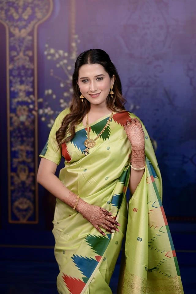 Woman in a green saree with a colorful design against a blue background
