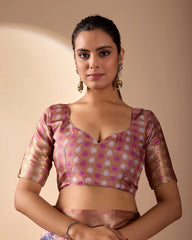 Woman wearing a patterned blouse against a beige background