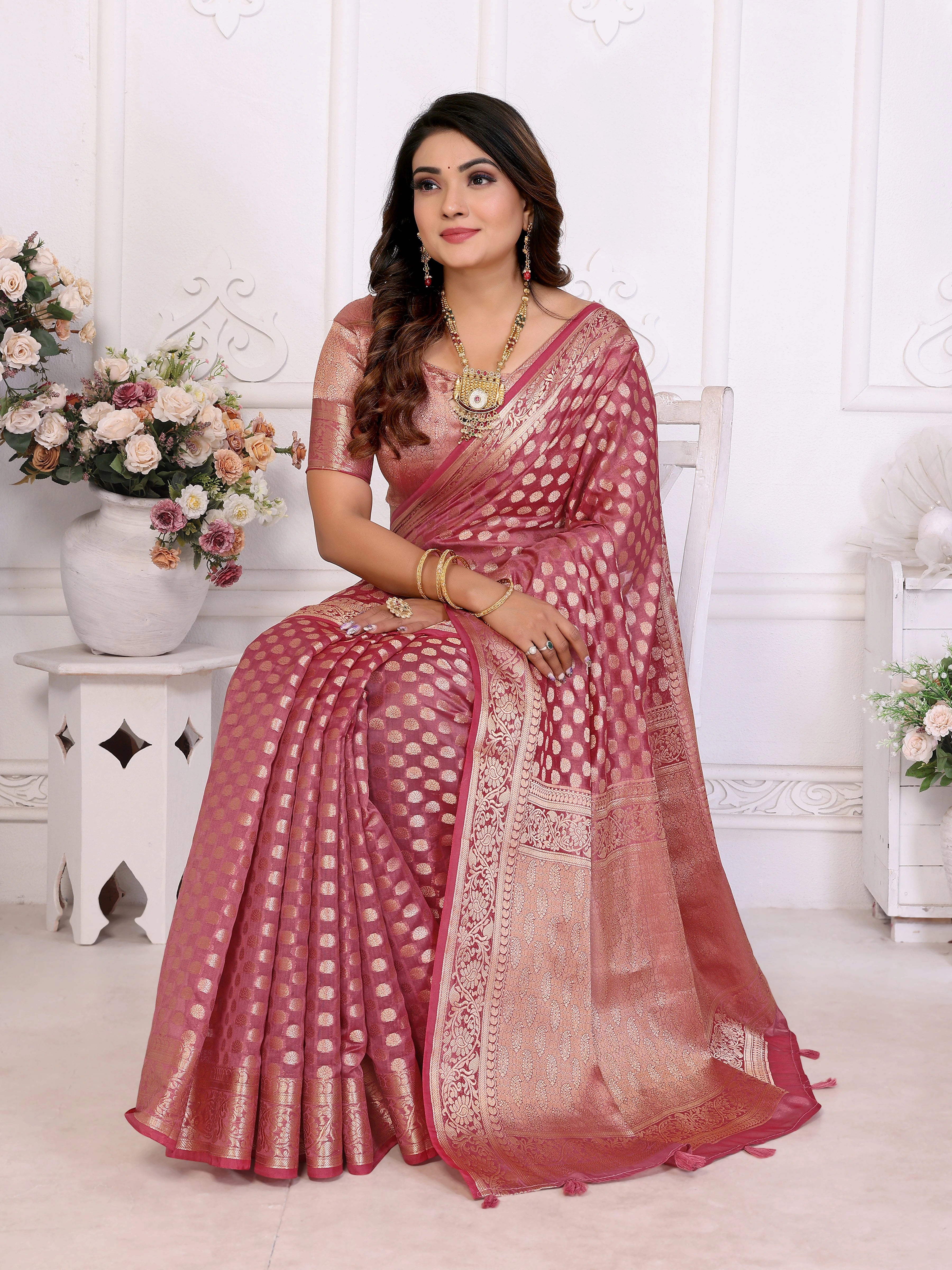 Woman wearing a pink saree with a white background