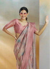 Woman wearing a pink saree with a plain background