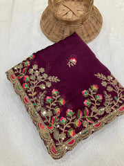 Embroidered purple fabric with floral patterns on a white background