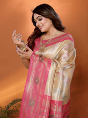 Woman wearing a pink and gold saree with jewelry against an orange background