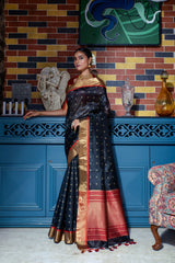 Close up of black saree with intricate zari work and gold red border