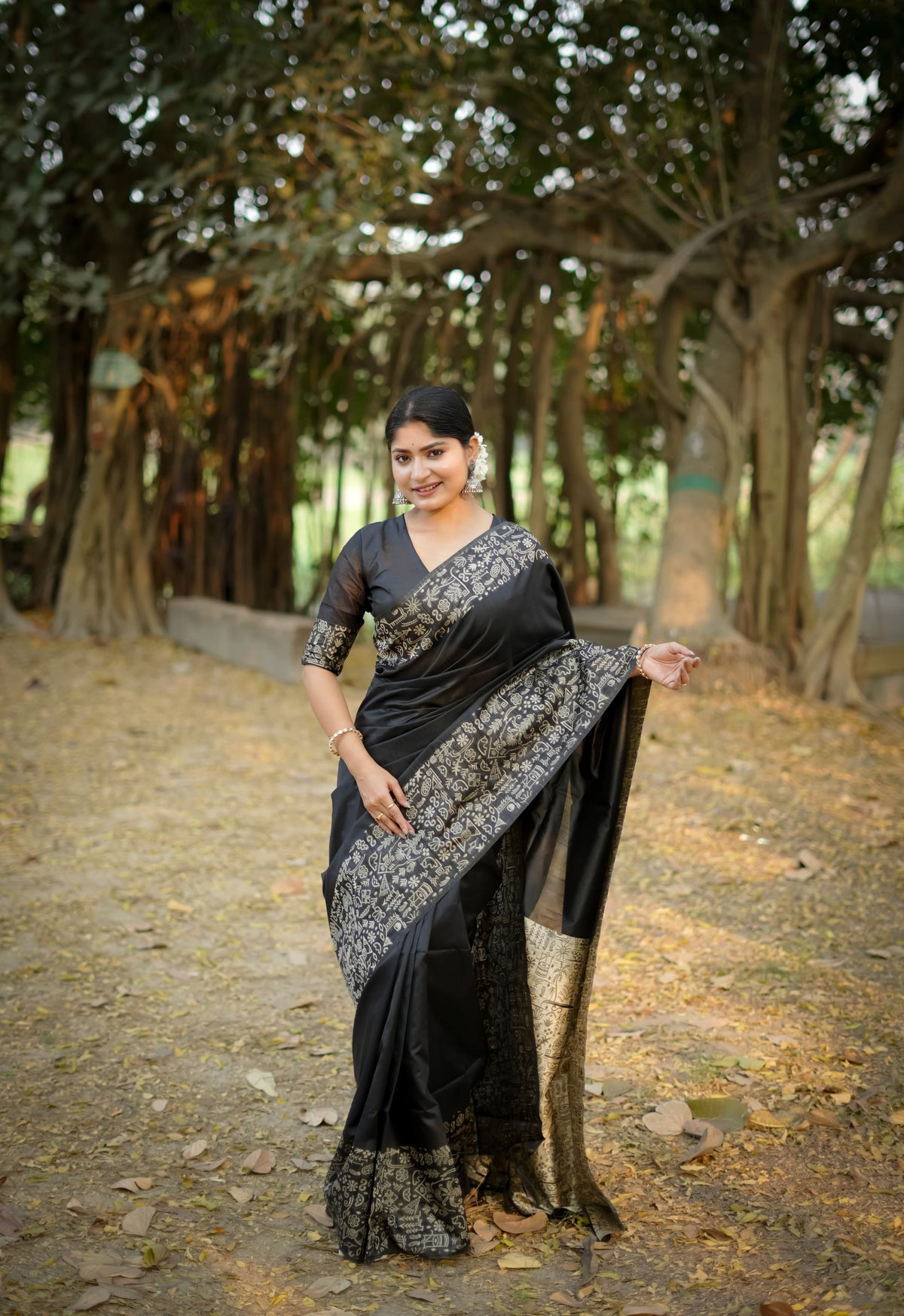 Black saree with zari work in an outdoor setting
