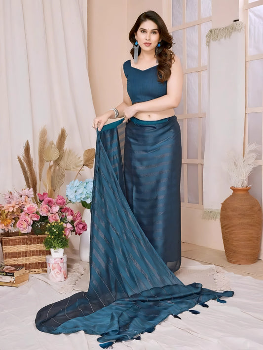 Woman wearing a blue saree with subtle sequin stripes and a sleeveless blouse, accessorized with blue earrings and silver jewelry, standing in a modern interior decorated with vases of pink and blue flowers, dried foliage, and a large terracotta pot.

Related
File name: vibrant-geometric-art
Alt text: Bright geometric shapes forming an eye-catching abstract design
Woman wearing a blue saree with subtle sequin stripes and a sleeveless blouse, accessorized with blue earrings and silver jewelry, standing.