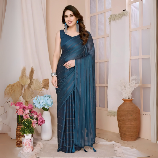 Woman wearing a blue saree with subtle sequin stripes and a sleeveless blouse, accessorized with blue earrings and silver jewelry, standing in a modern interior decorated with vases of pink and blue flowers, dried foliage, and a large terracotta pot.

Related
File name: vibrant-geometric-art
Alt text: Bright geometric shapes forming an eye-catching abstract design.
