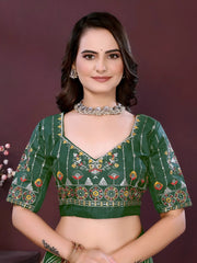 Woman wearing a dark green digital print saree with embroidery work and a contrast patterned border, paired with a matching blouse in an indoor studio product image, Indian ethnic wear