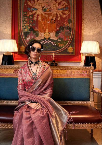 Woman seated in dark pink zari work saree with ornate blouse and bold jewelry exuding traditional elegance