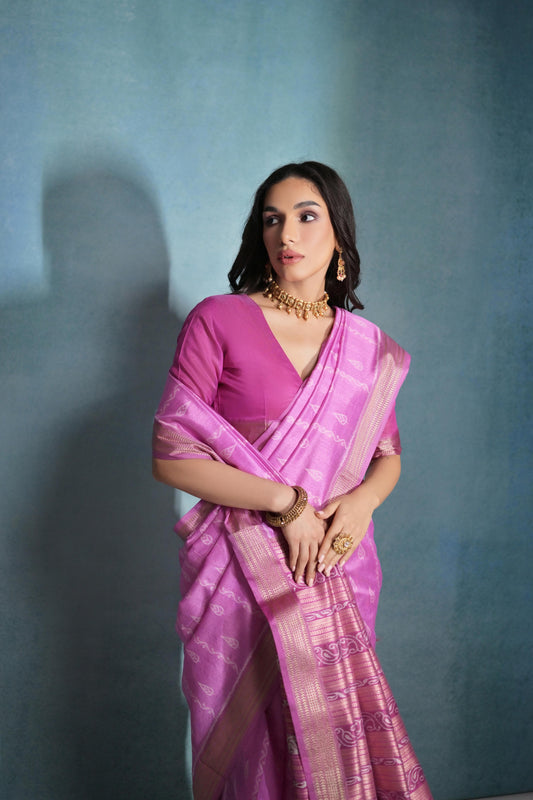 Deep pink saree featuring intricate ikkat and zari weaving, showcasing traditional handloom textile craftsmanship