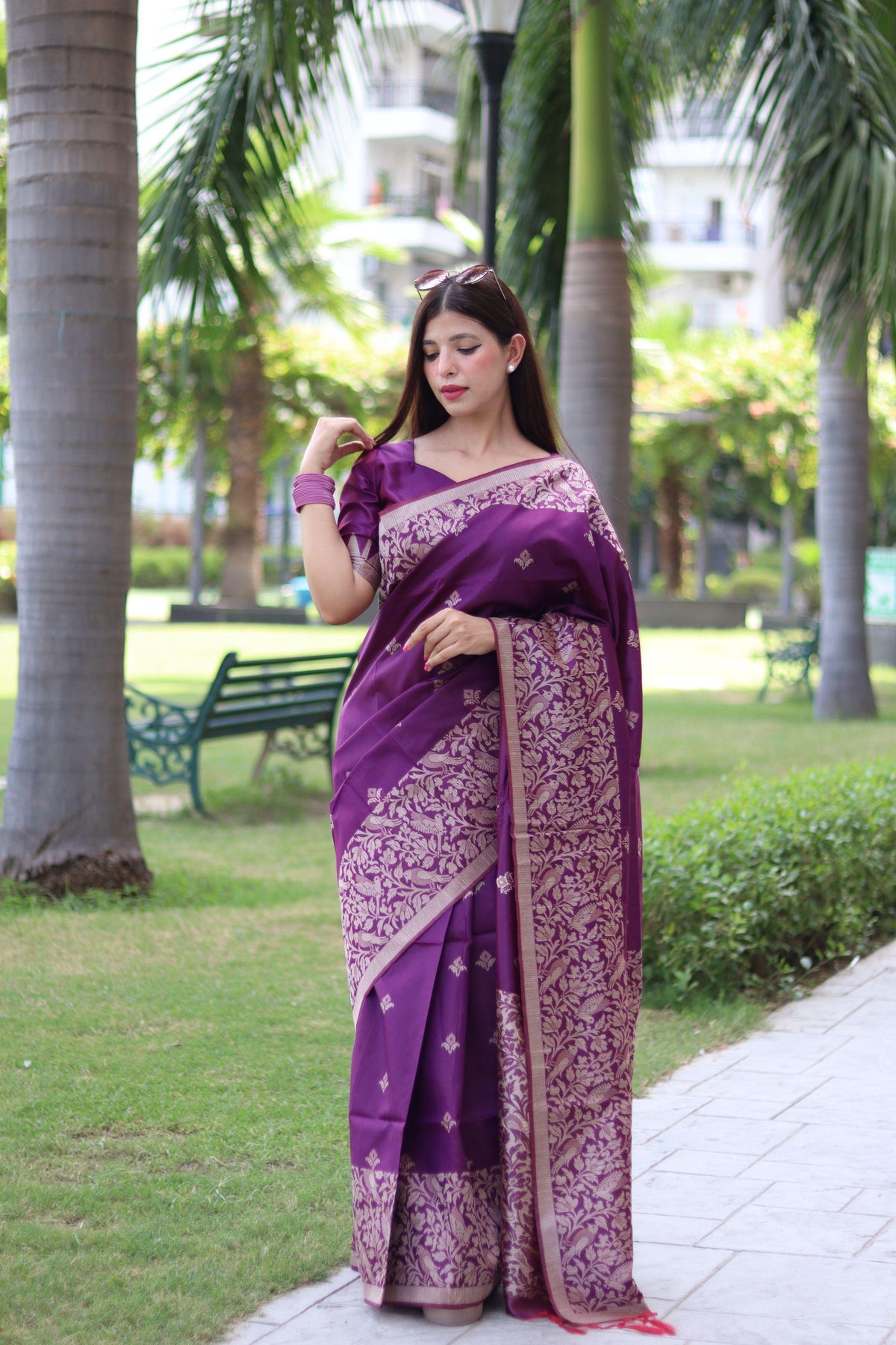 Woman draped in deep shade purple traditional weaving saree reflecting graceful ethnic elegance in a vintage setting