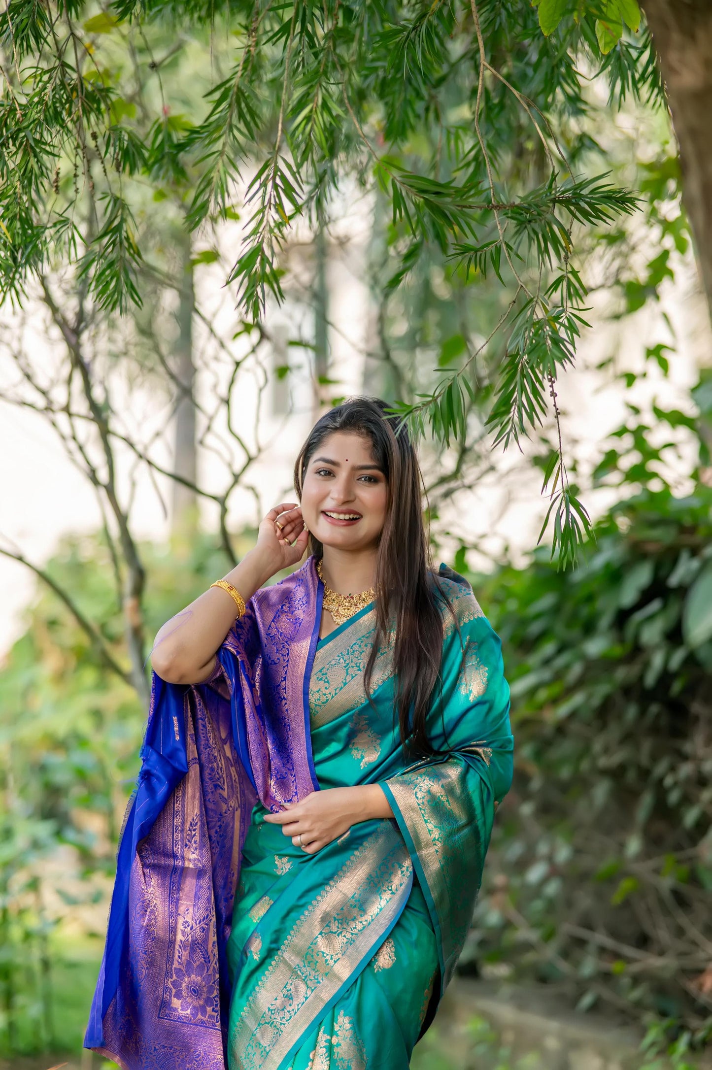 Deep teal saree with zari work and contrasting purple pallu